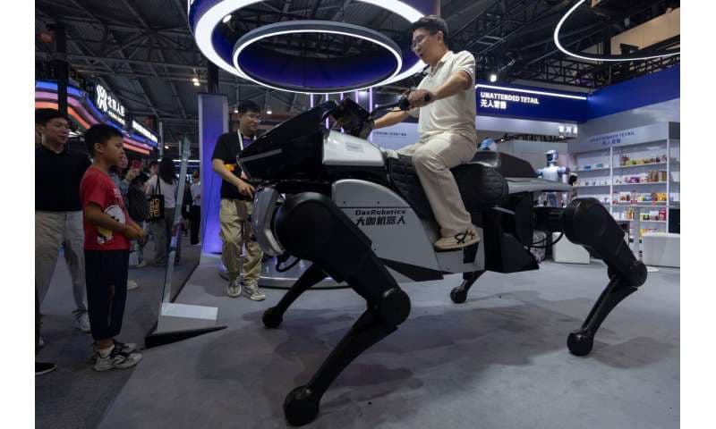 A man rides a robot from DaxRobotics, a Chinese AI and robotics startup, during the World AI Conference in Shanghai, Friday, July 17, 2026. Credit: AP Photo/Ng Han Guan