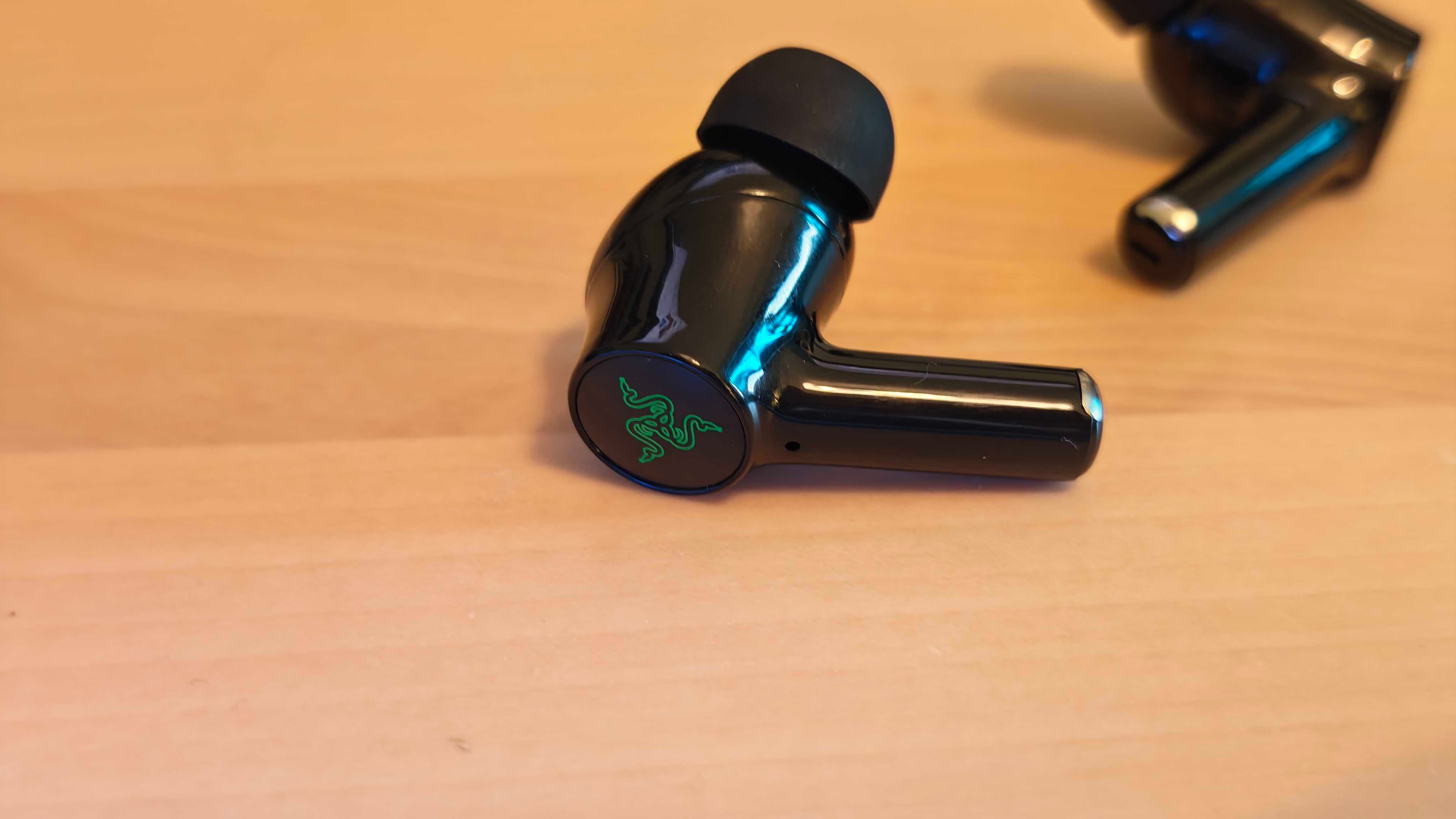 The Razer Hammerhead HyperSpeed gaming earbuds on a blank desktop surface.