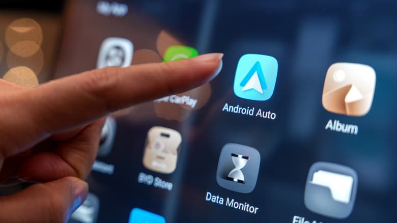 Woman about to touch the Android Auto icon on the car's screen