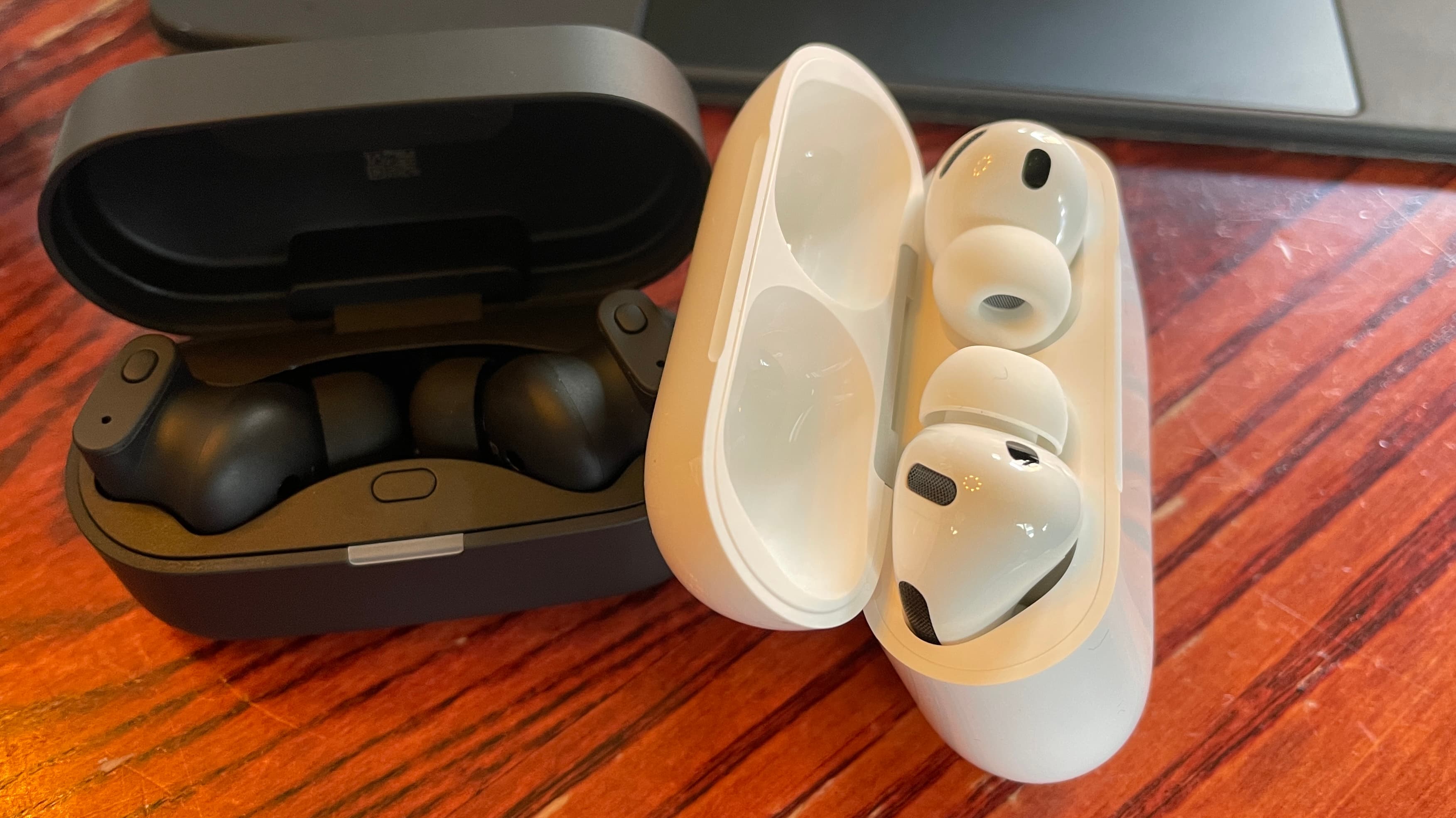 Status Audio Pro X GoldenSound, next to AirPods or held in a hand, with gold accents showing