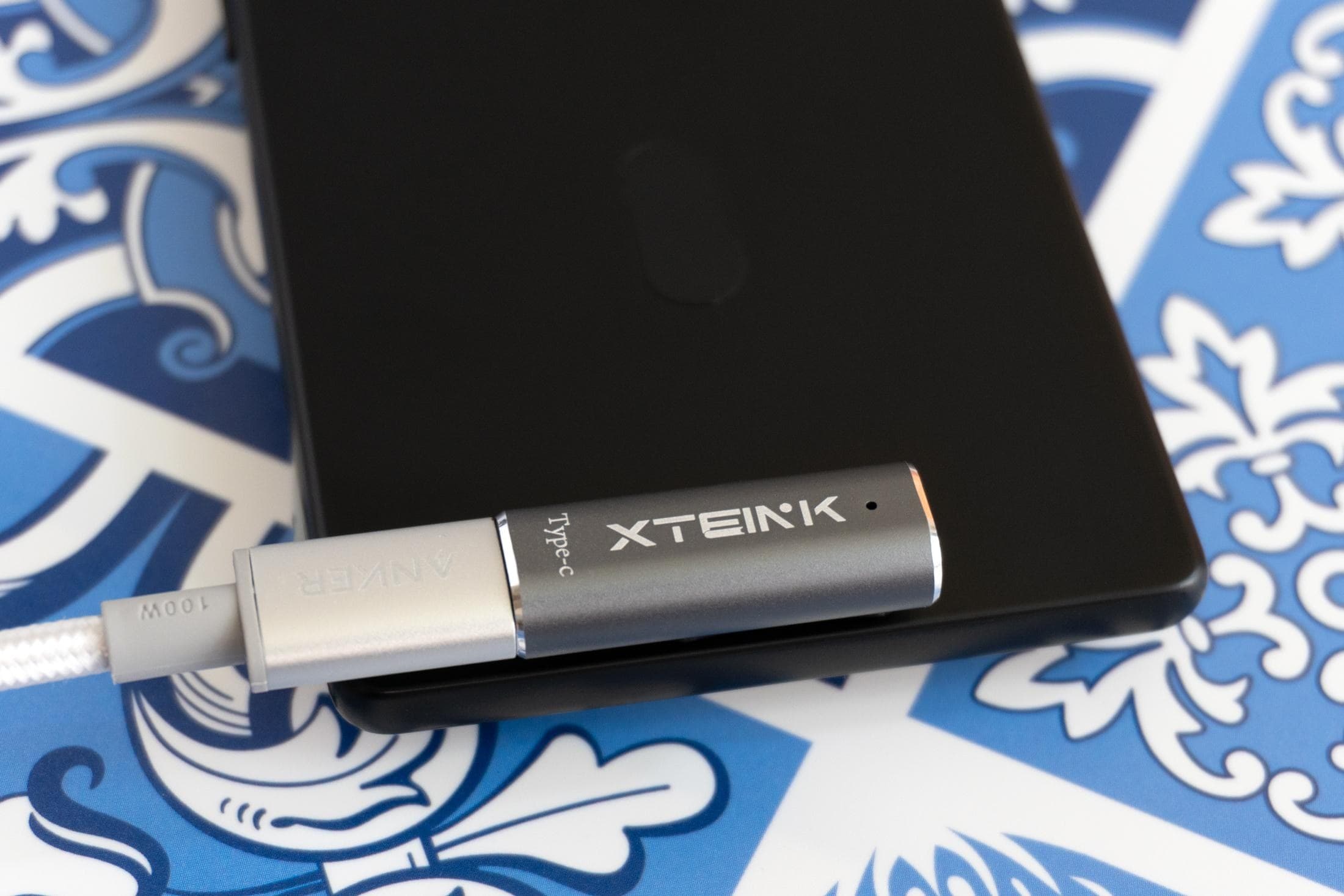 A close-up of a magnetic pogo-pin charger attached to the back of the Xteink X4 Pro.