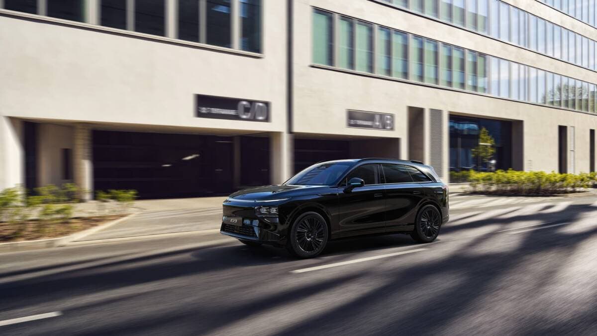 Black XPeng electric car on a city street with urban architecture