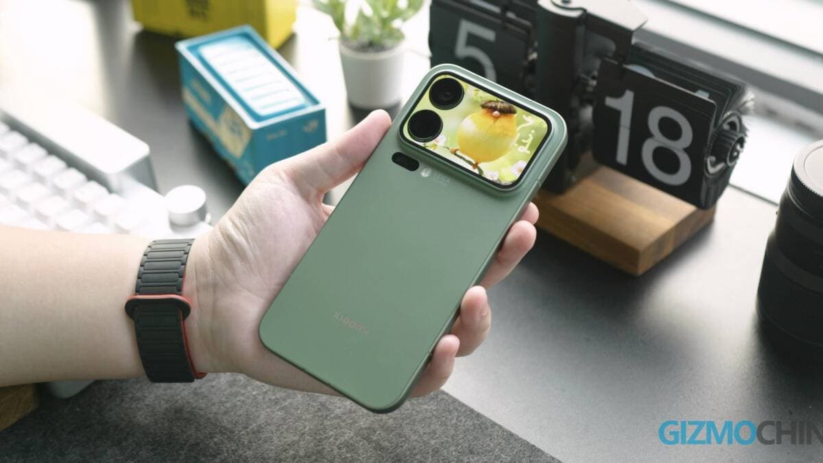 A person holds a Xiaomi 18 Pro smartphone with a camera and removable body