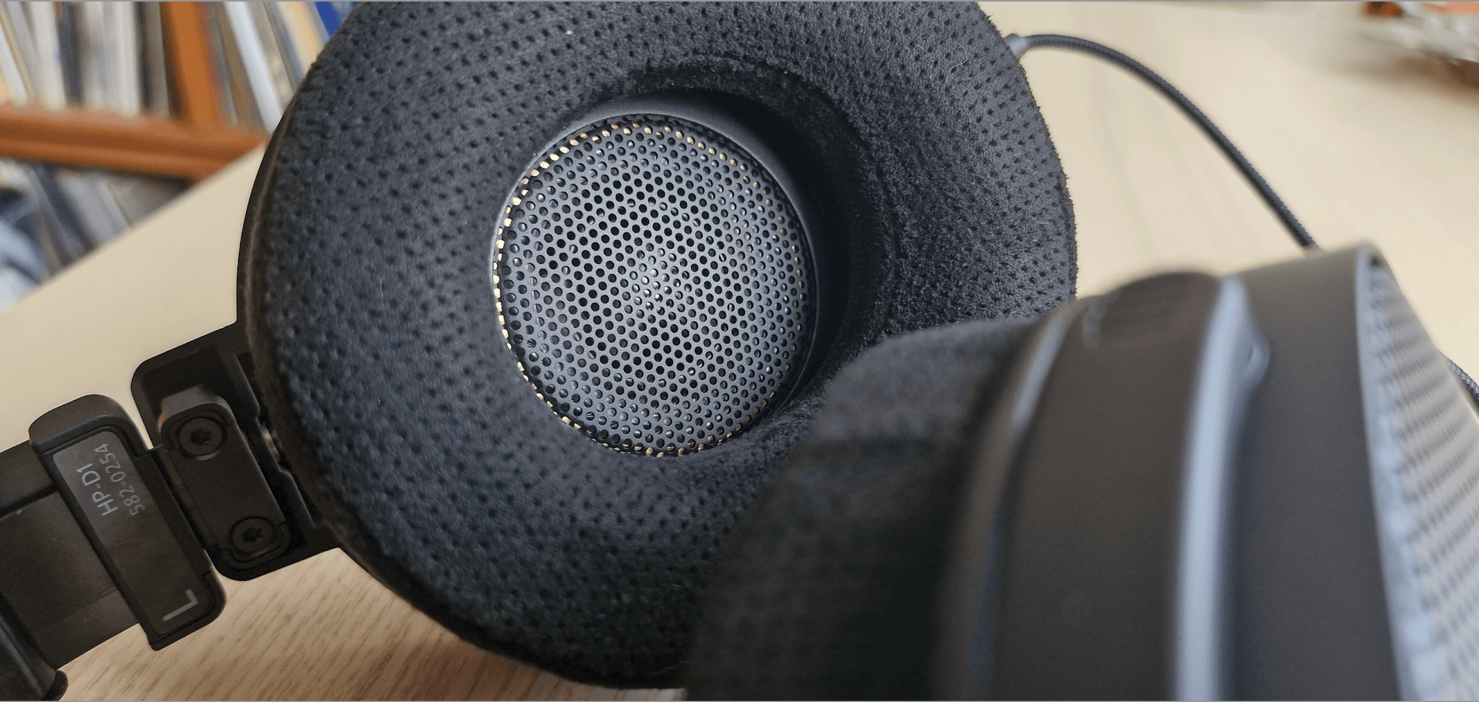 Primer plano del HEDDphone D1 sobre una mesa beige, con un hermoso gato