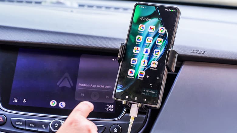 Phone connected to the car's system by wired, with Android Auto in the background