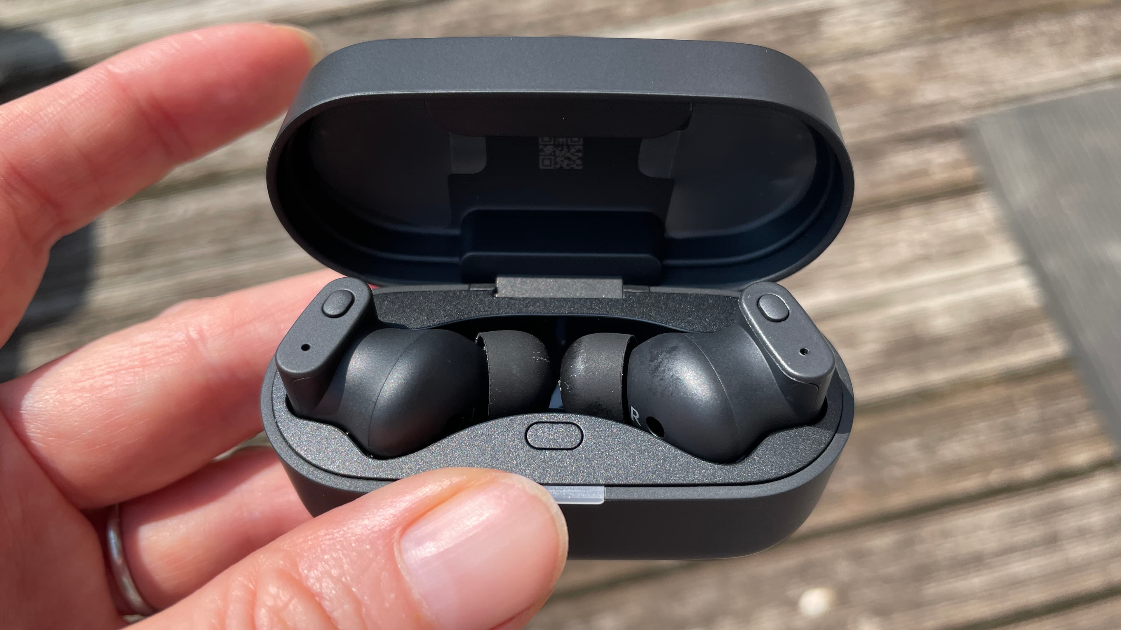 Status Audio Pro X GoldenSound, next to AirPods or held in a hand, with gold accents showing