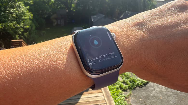 A wrist outside with an Apple Watch showing the water lock feature on.