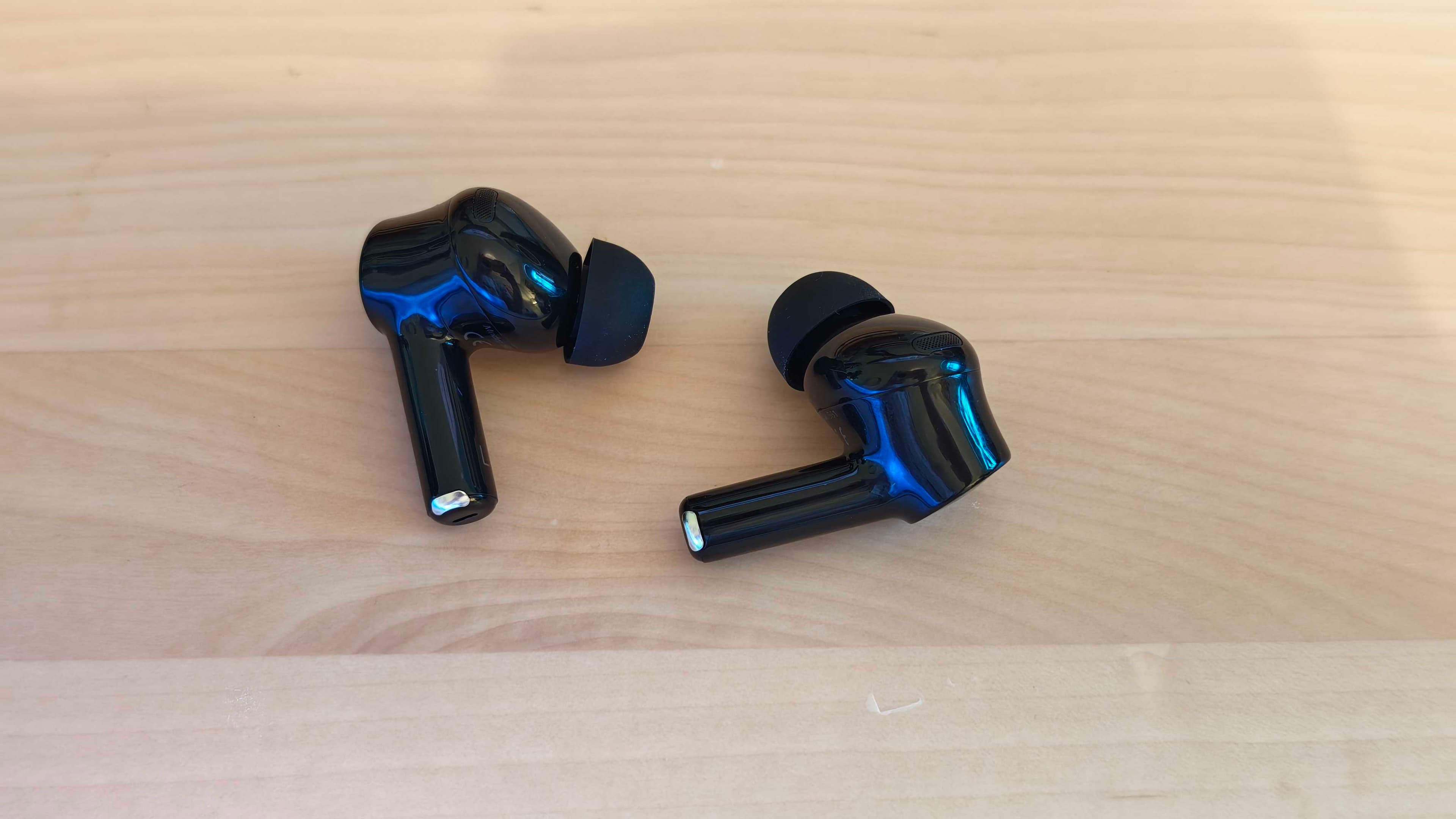 The Razer Hammerhead HyperSpeed gaming earbuds on a blank desktop surface.